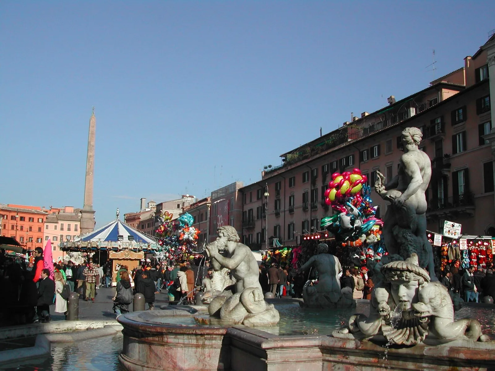 Piazza Navona durante il mercatino natalizio, con la fontana del Moro, l'obelisco e una giostra